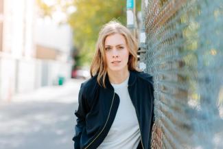 Leah Nieboer leans against a metal fence