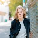 Leah Nieboer leans against a metal fence